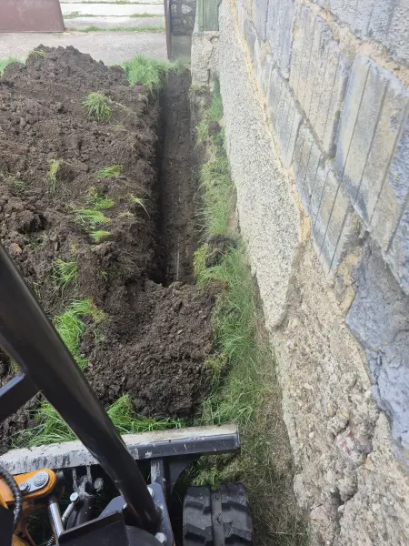 Az árok a kőlábazat mellett, gépi kiemeléssel.